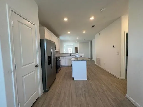 a kitchen with stainless steel appliances a refrigerator and wooden floor