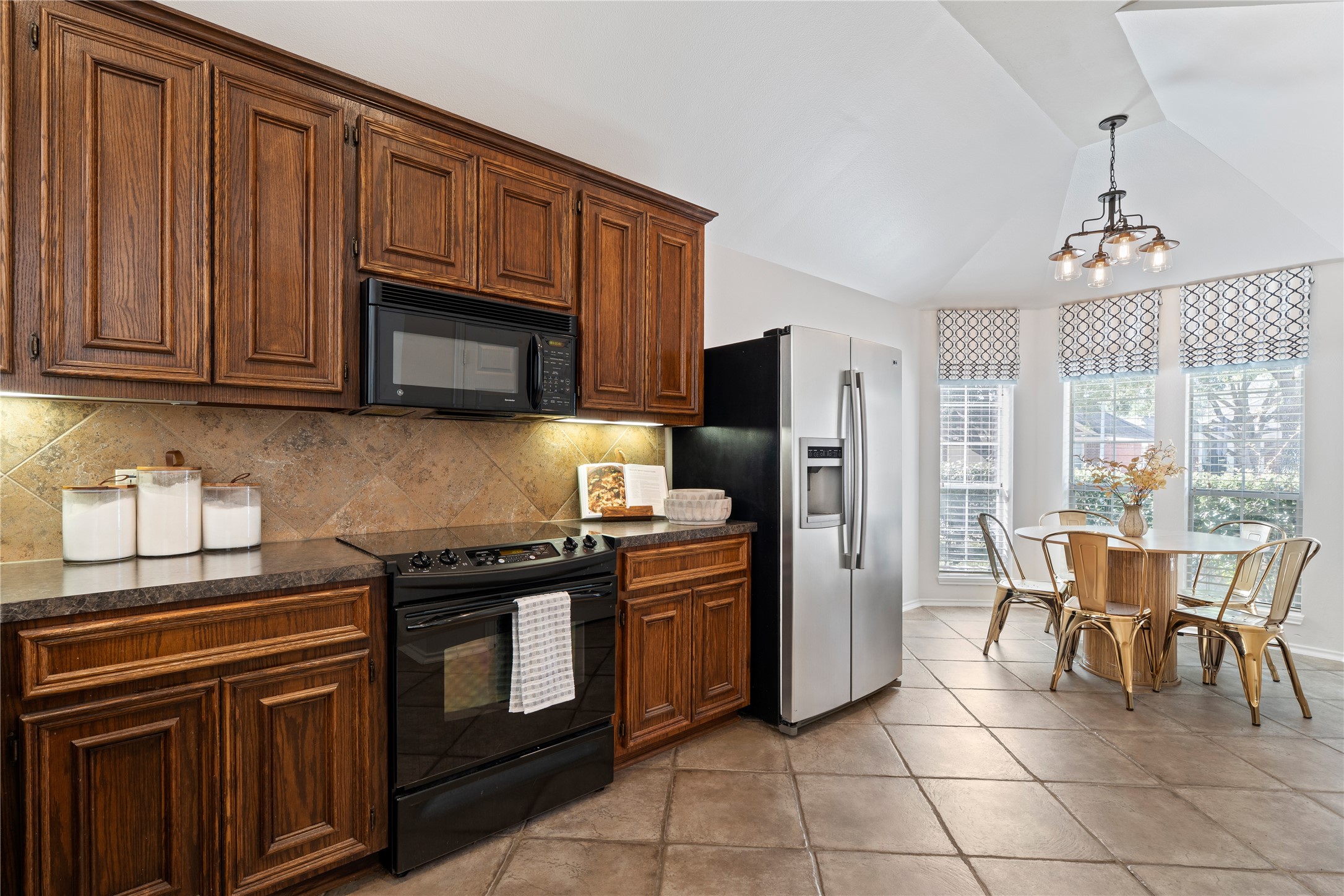 4323 Sunlit Pass Loop Humble, TX 77396 - Photo 5 of 30 a kitchen with granite countertop a stove cabinets and stainless steel appliances