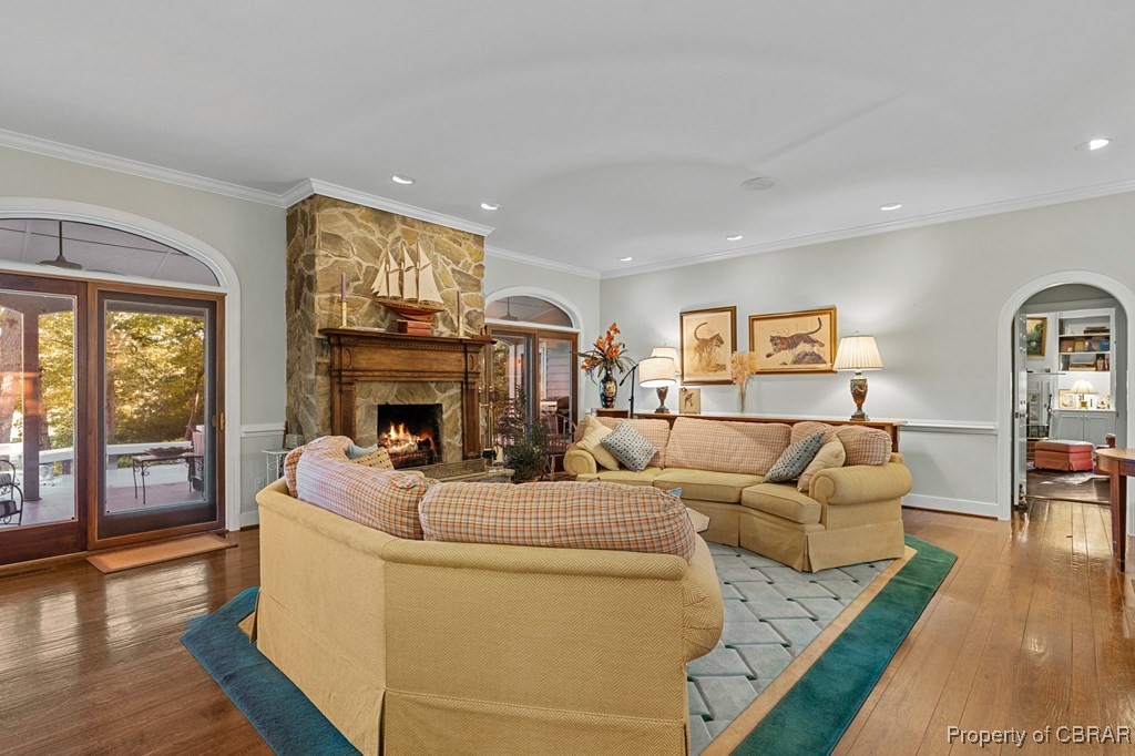 184 York Road Irvington, VA 22480 - Photo 13 of 46 Living room with hardwood / wood-style floors, a stone fireplace, and ornamental molding