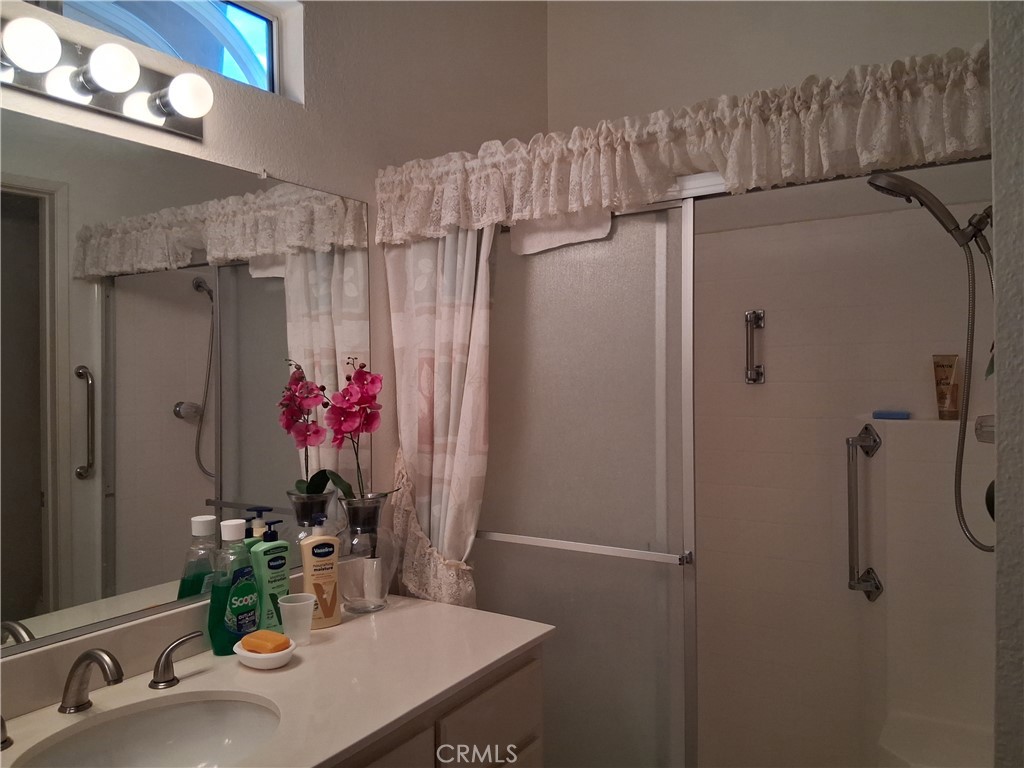 6353 Colonial Avenue Banning, CA 92220 - Photo 13 of 26 a bathroom with a granite countertop shower a sink and a mirror