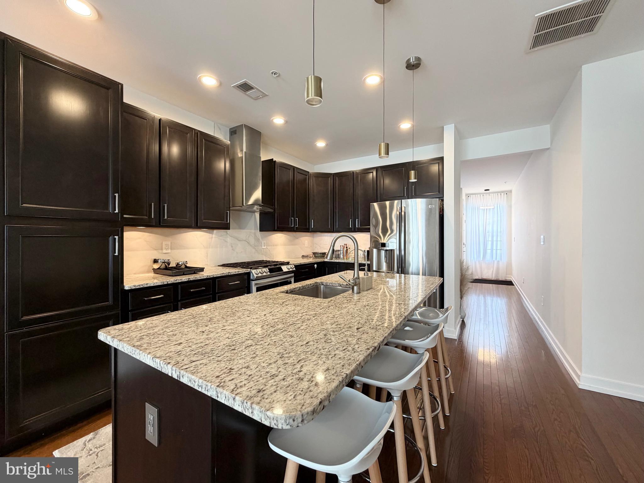 308 Roarks Trail Warminster, PA 18974 - Photo 10 of 68 a kitchen with a table a refrigerator and a stove top oven with wooden floor