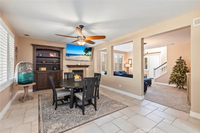 a dining room with furniture a floor to ceiling window and fire place