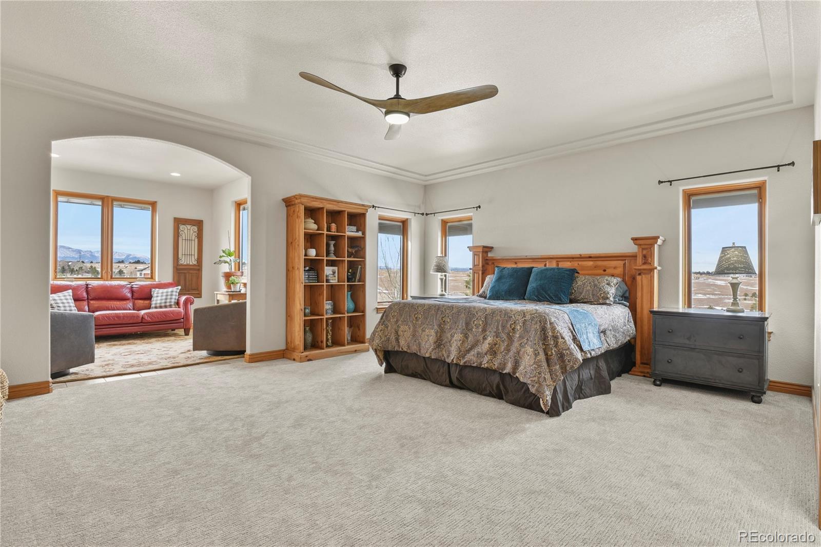 5220 Roundup Ridge Road Colorado Springs, CO 80908 - Photo 15 of 50 a bedroom with a large bed and a chandelier