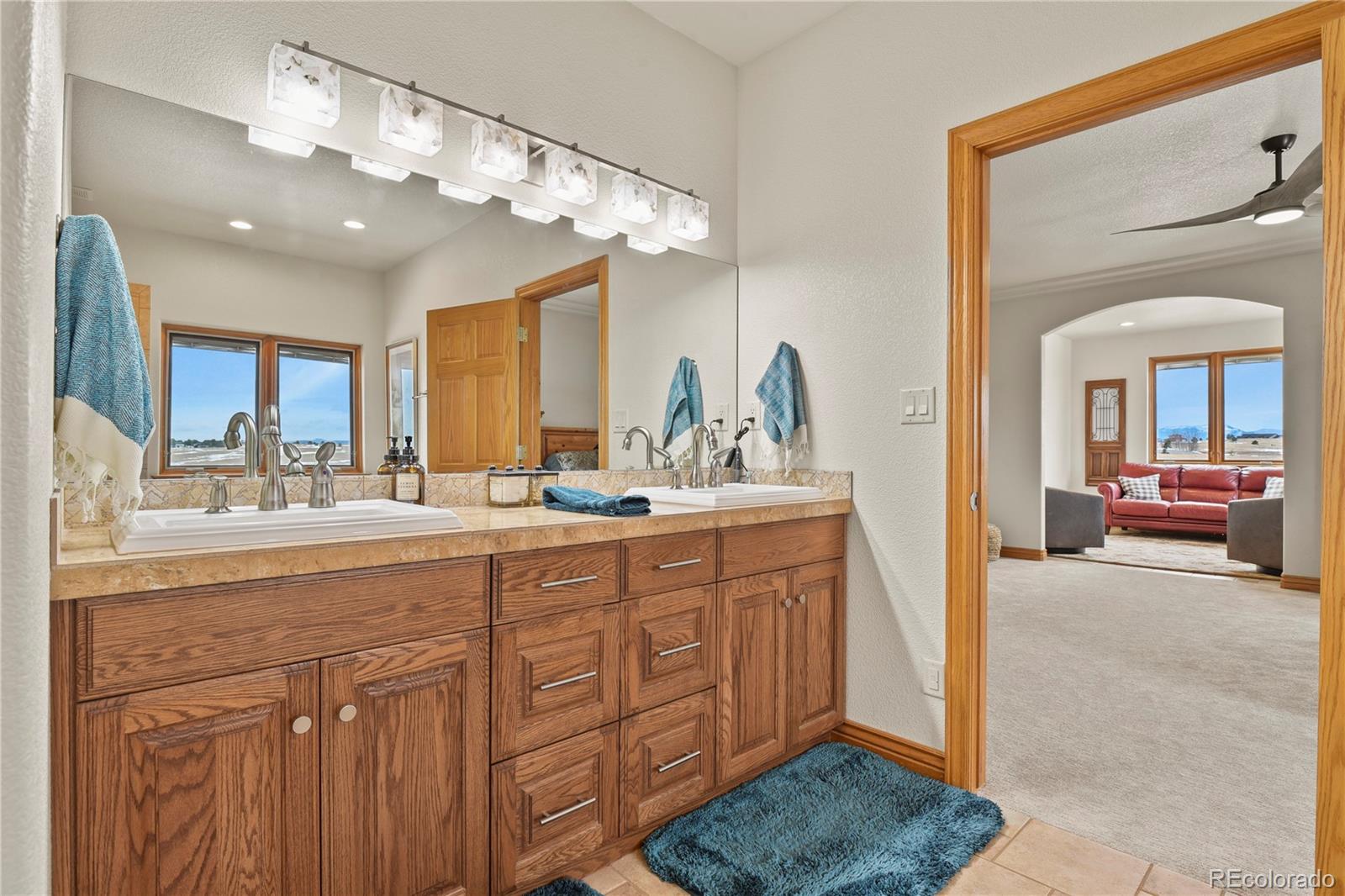 5220 Roundup Ridge Road Colorado Springs, CO 80908 - Photo 17 of 50 a spacious bathroom with a sink a large mirror and vanity