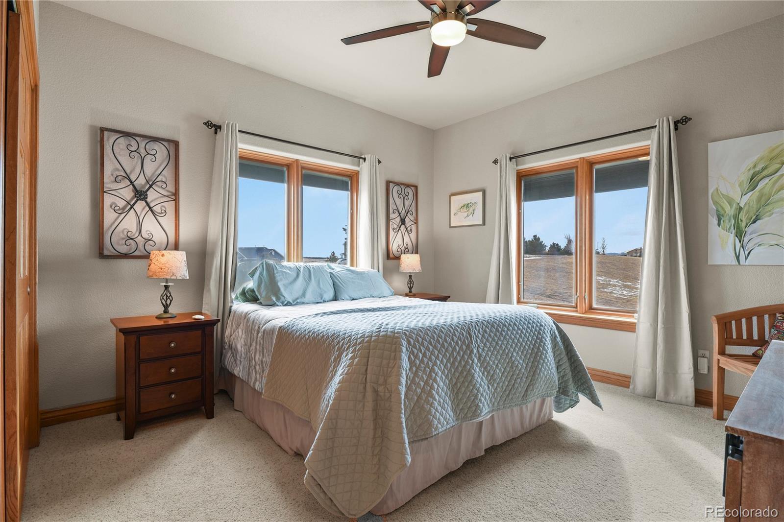 5220 Roundup Ridge Road Colorado Springs, CO 80908 - Photo 19 of 50 a bedroom with a bed and a chandelier