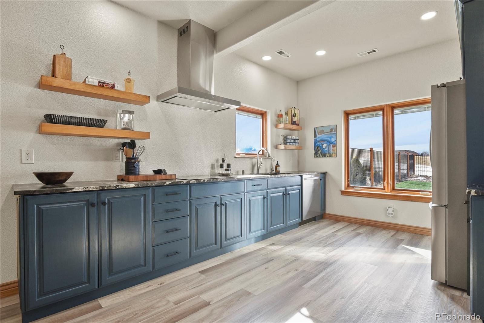 5220 Roundup Ridge Road Colorado Springs, CO 80908 - Photo 24 of 50 a kitchen with stainless steel appliances granite countertop a sink stove and wooden cabinets