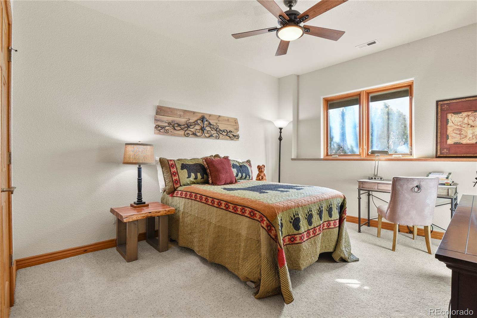 5220 Roundup Ridge Road Colorado Springs, CO 80908 - Photo 31 of 50 a bedroom with a bed and a chandelier