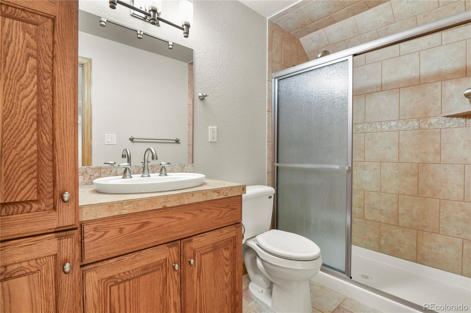 5220 Roundup Ridge Road Colorado Springs, CO 80908 - Photo 36 of 50 a bathroom with a sink toilet and shower
