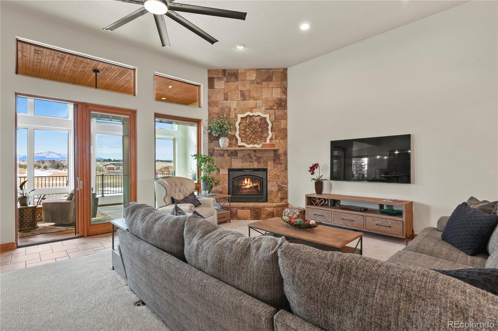 5220 Roundup Ridge Road Colorado Springs, CO 80908 - Photo 6 of 50 a living room with furniture a flat screen tv and a fireplace