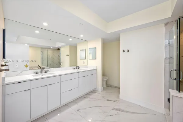 a large bathroom with a double vanity sink a mirror and a bathtub