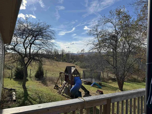 a view of a wooden deck and a backyard of the house