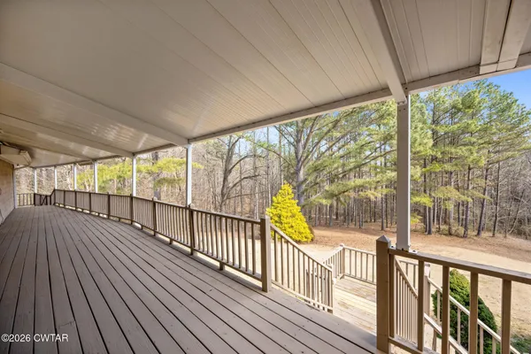 a view of a roof deck with couches and wooden fence