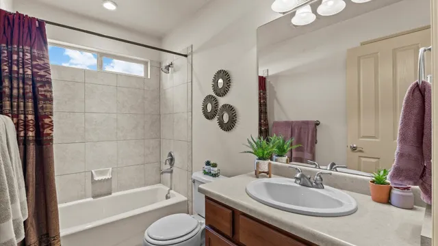 a bathroom with a granite countertop tub sink and mirror