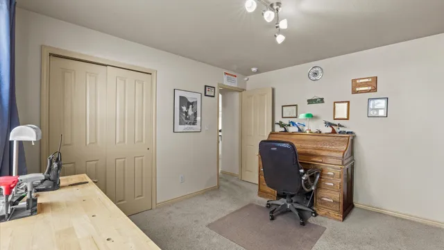 a view of a workspace with furniture and a window