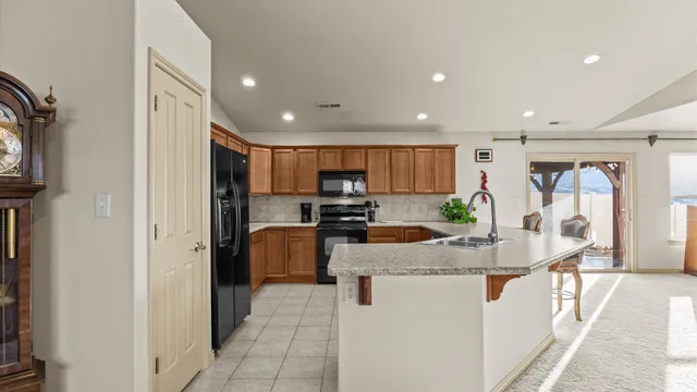 a kitchen with stainless steel appliances granite countertop a refrigerator and a stove top oven