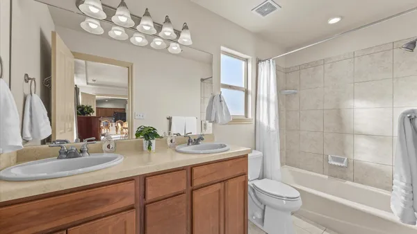 a bathroom with a granite countertop tub sink and mirror