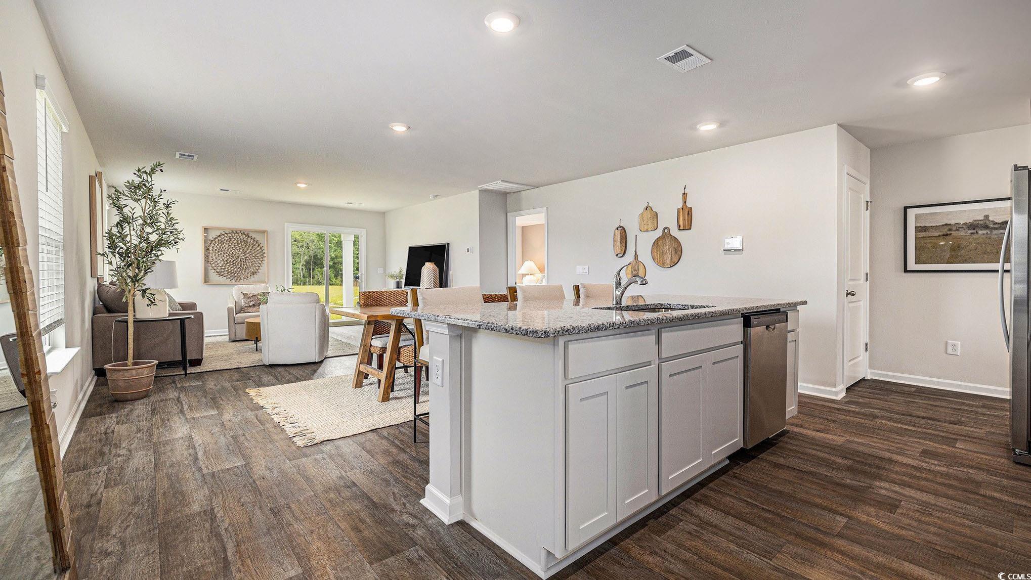 117 Homestead Way Myrtle Beach, SC 29588 - Photo 23 of 23 Kitchen featuring a center island with sink, light stone counters, open floor plan, dark wood-type flooring, and recessed lighting