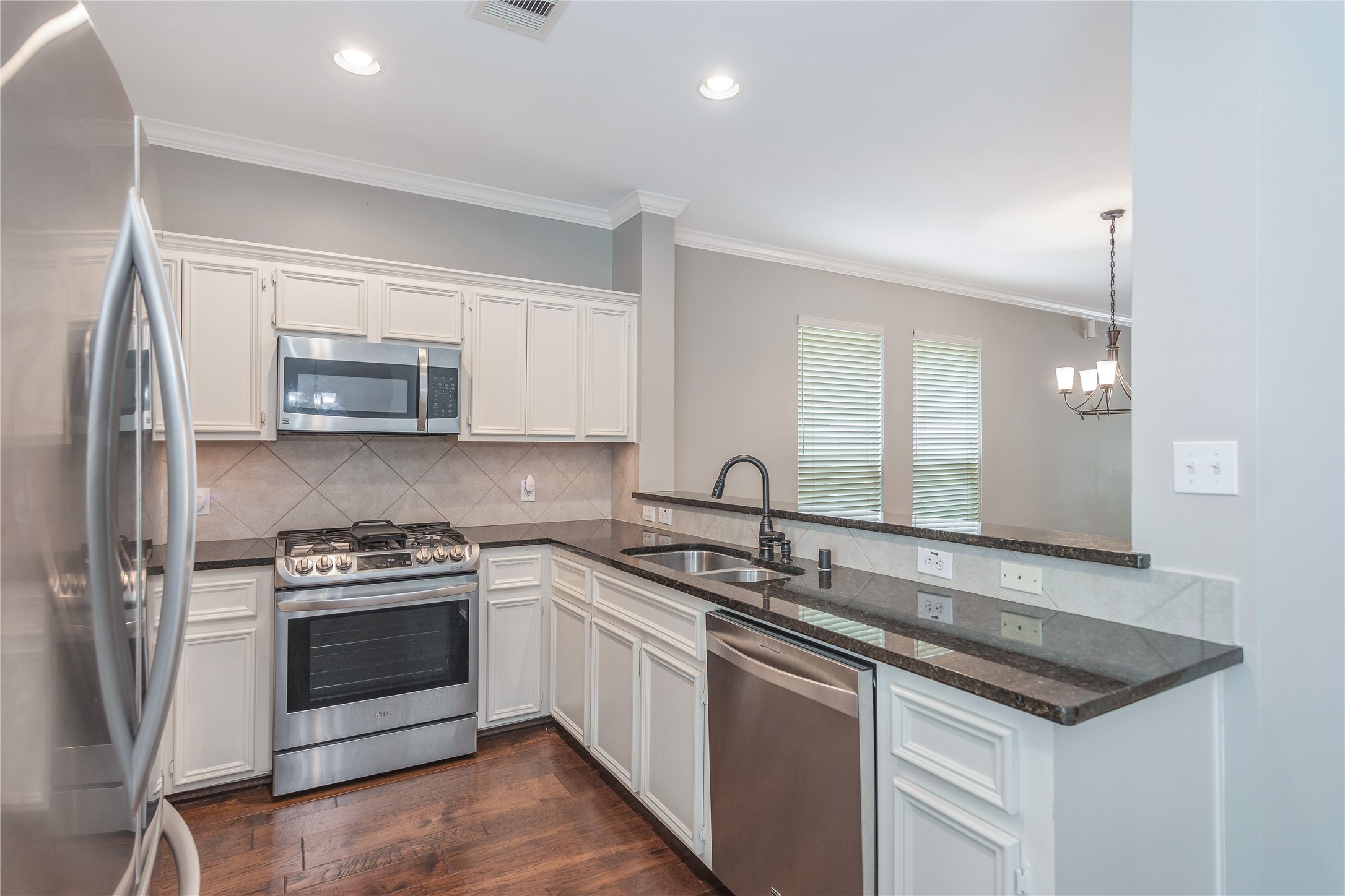 1207 Nagle Street Houston, TX 77003 - Photo 14 of 26 This kitchen offers stainless steel appliances and tile backsplash overlooking the dining and living areas.
