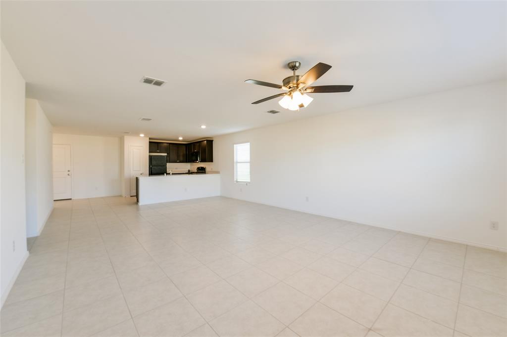 340 Dry Cyn Way Haslet, TX 76052 - Photo 13 of 15 an empty room with a kitchen and a ceiling fan