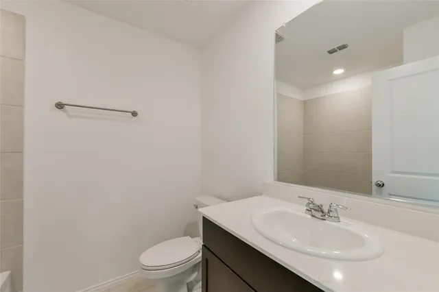 a bathroom with a sink a toilet and a mirror