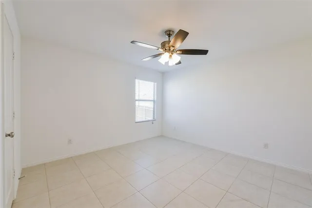 an empty room with a window and a fan