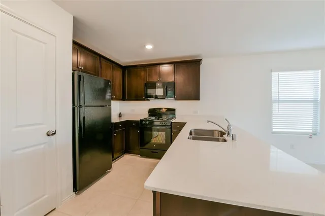 a kitchen with a refrigerator a stove top oven a sink and dishwasher