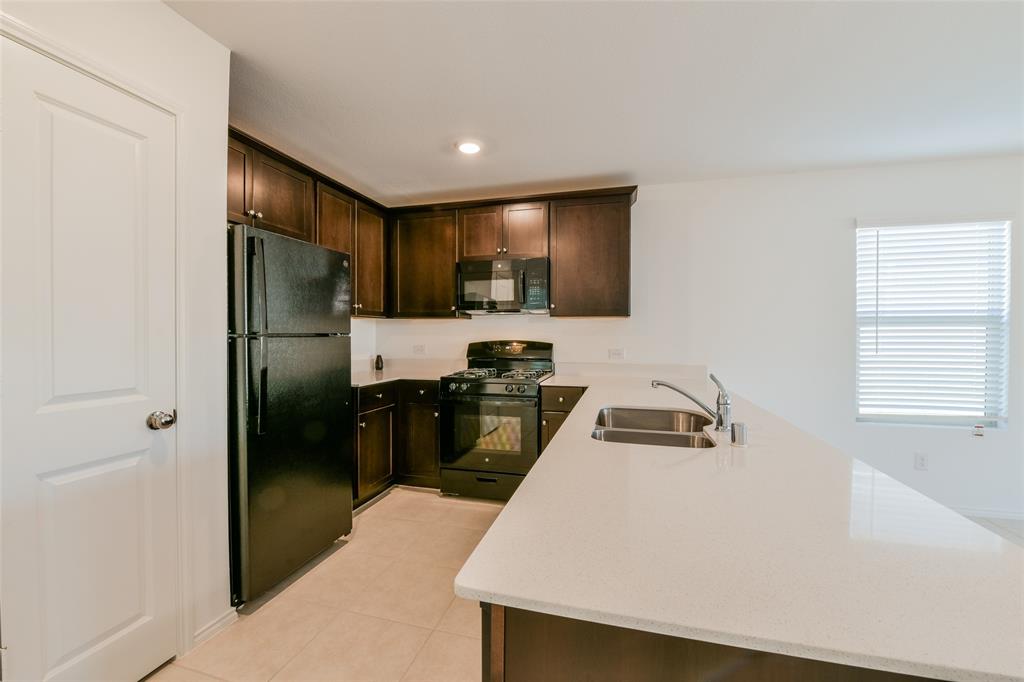 340 Dry Cyn Way Haslet, TX 76052 - Photo 10 of 15 a kitchen with a refrigerator a stove top oven a sink and dishwasher