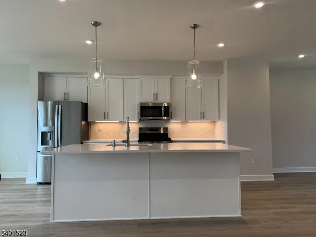 a kitchen with kitchen island a refrigerator and a stove