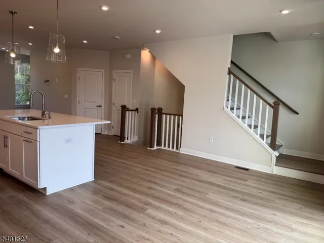 a kitchen with a sink and wooden floor