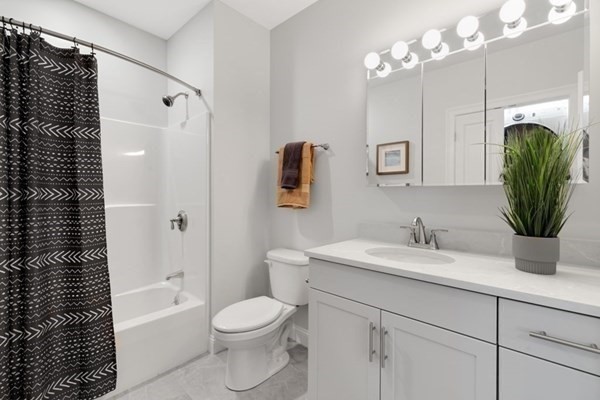 320 Middlesex Avenue, Unit B110 Medford, MA 02155 - Photo 14 of 19 a bathroom with a granite countertop sink a toilet and bathtub