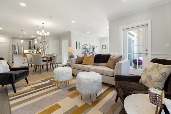 320 Middlesex Avenue, Unit B110 Medford, MA 02155 - Photo 7 of 19 a living room with furniture and a chandelier
