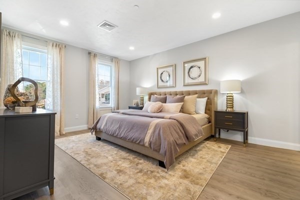 320 Middlesex Avenue, Unit B110 Medford, MA 02155 - Photo 9 of 19 a spacious bedroom with a bed and wooden floor