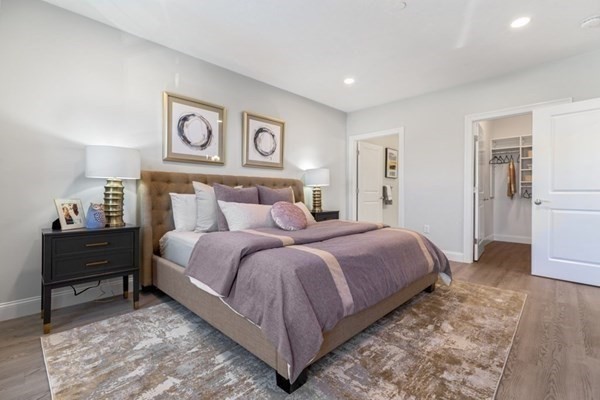 320 Middlesex Avenue, Unit B110 Medford, MA 02155 - Photo 10 of 19 a bedroom with a bed and wooden floor