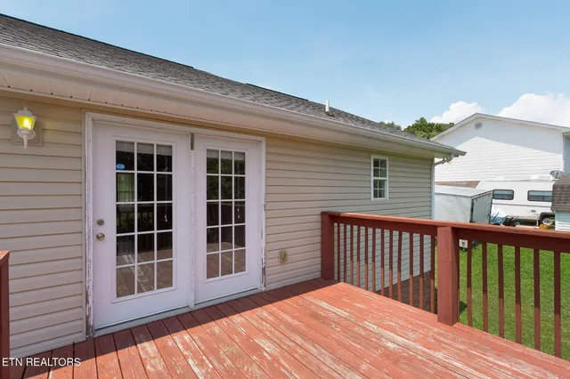 a view of a wooden balcony with a floor to ceiling window