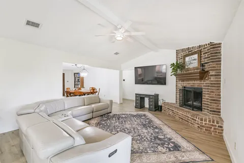 a living room with furniture a flat screen tv and a fireplace