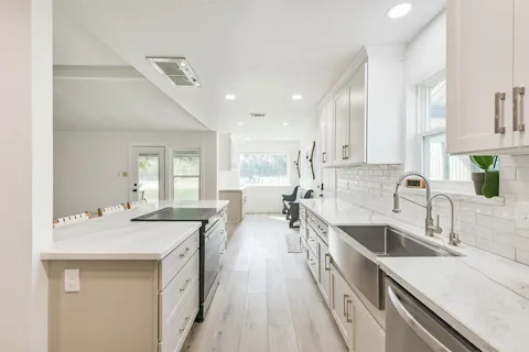 a kitchen with sink stove and cabinets