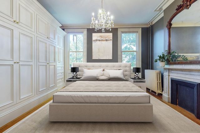 a spacious bedroom with a balcony a bed and a chandelier