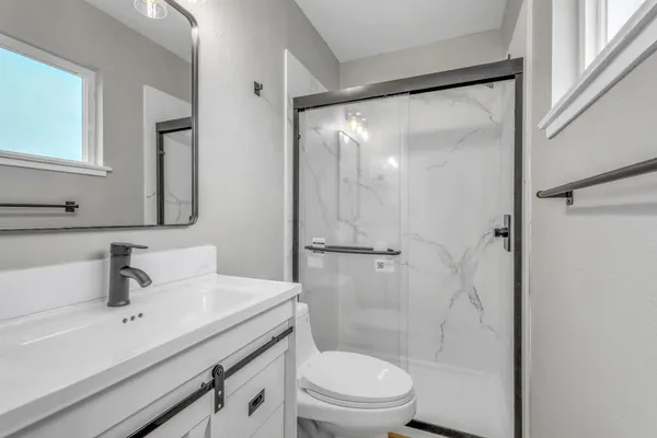 a bathroom with a sink mirror toilet and shower