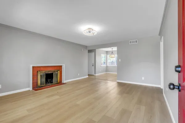 wooden floor fireplace and windows in an empty room