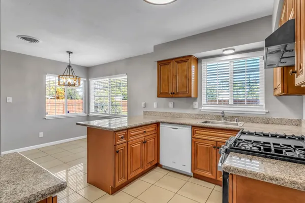 a kitchen with stainless steel appliances granite countertop a stove a sink and a microwave