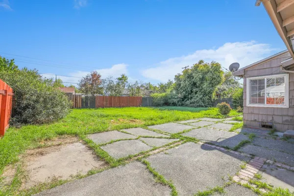 a view of backyard with swimming pool and green space