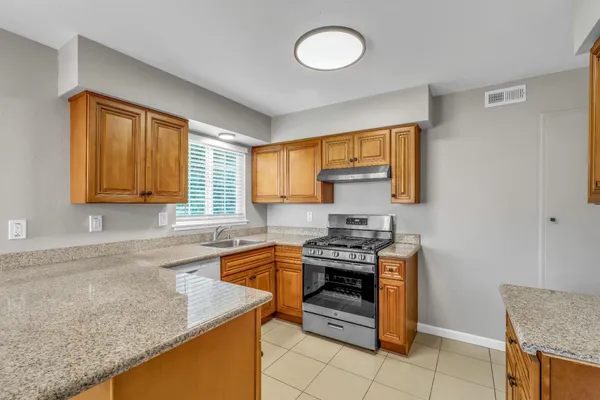a kitchen with stainless steel appliances granite countertop a sink stove and cabinets
