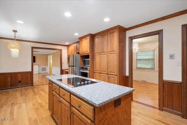 a kitchen with stainless steel appliances granite countertop a sink and a refrigerator