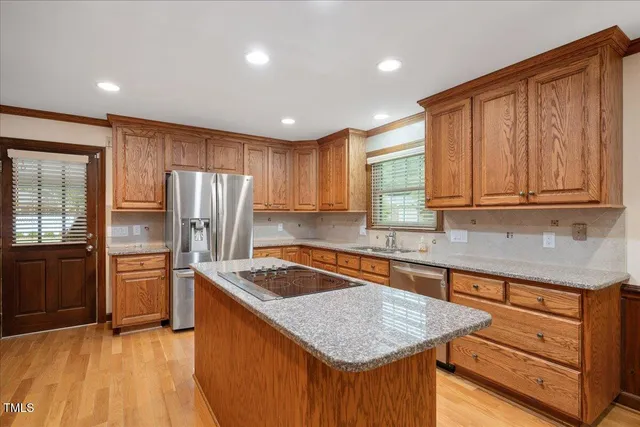 a kitchen with stainless steel appliances granite countertop refrigerator sink and cabinets