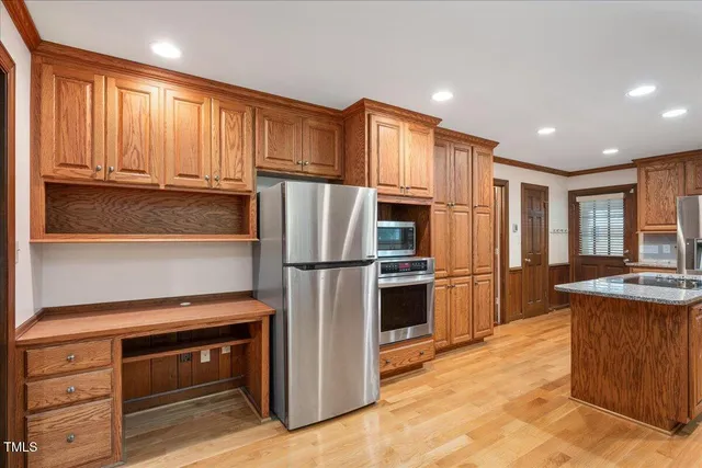 a kitchen with kitchen island granite countertop appliances cabinets and a counter space