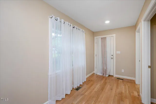 a view of an empty room with wooden floor