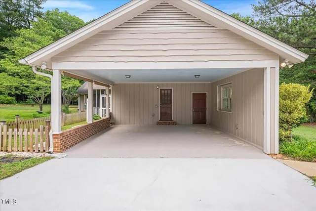 a view of a white house next to a yard with porch