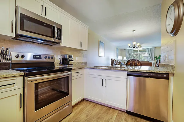 a kitchen with stainless steel appliances granite countertop a stove microwave and cabinets
