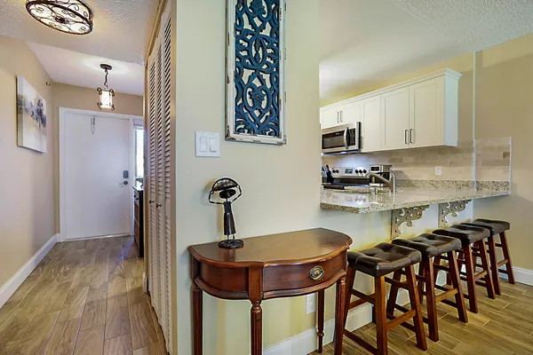 a kitchen with granite countertop a table chairs a sink and dishwasher