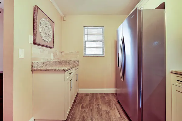 a bathroom with a granite countertop sink and a refrigerator